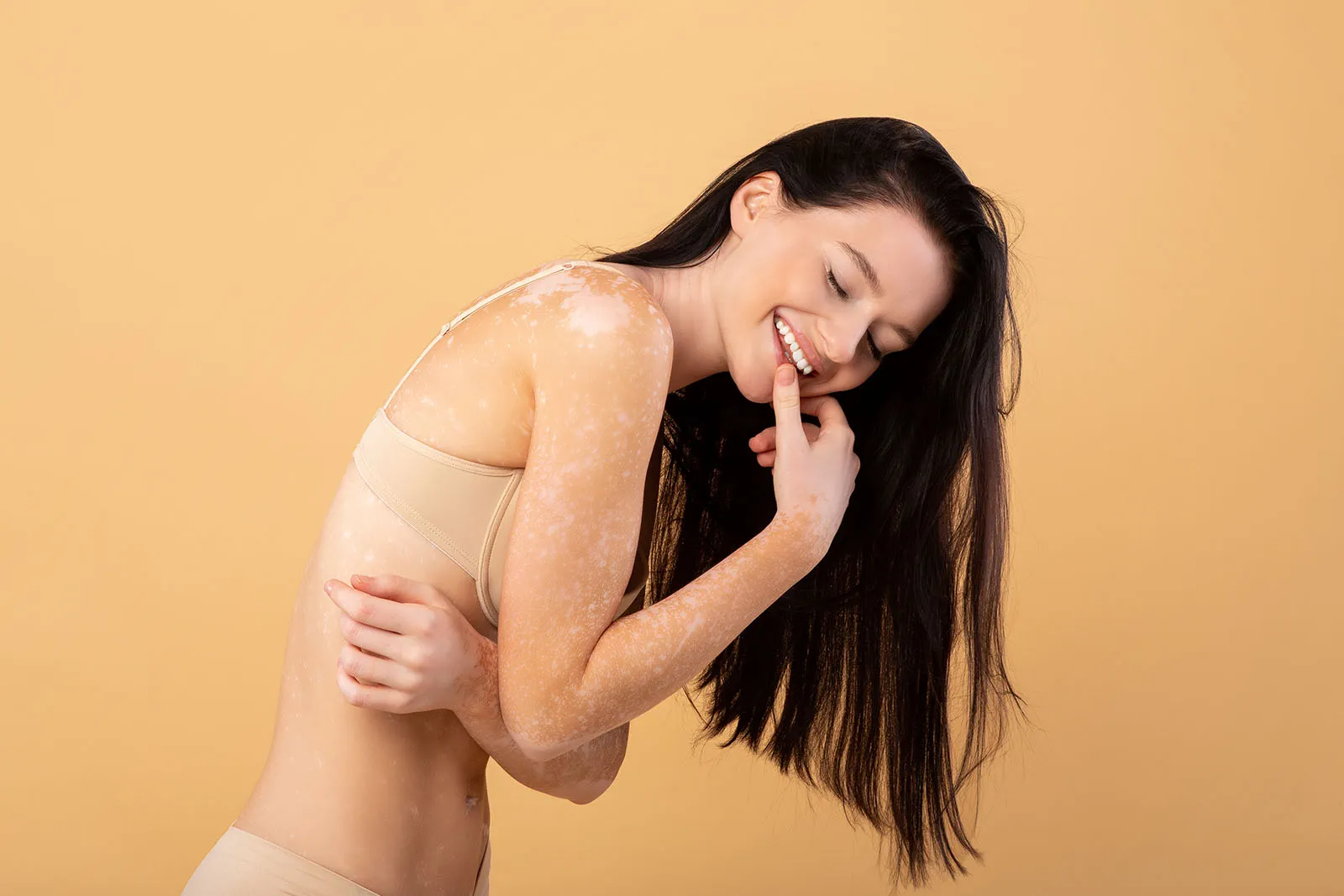 Mulher abraçando o próprio corpo em uma imagem editorial sobre cuidado corporal