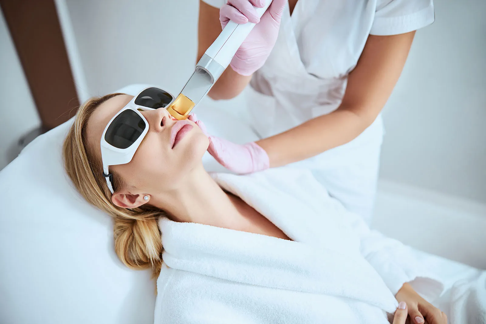 Pessoa usando proteção ocular durante aplicação ilustrativa de laser facial